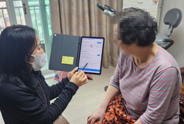 광주 광산구 관계자가 홀몸 어르신에게 스마트기기 활용 건강관리 방법을 안내하고 있다 사진광산구